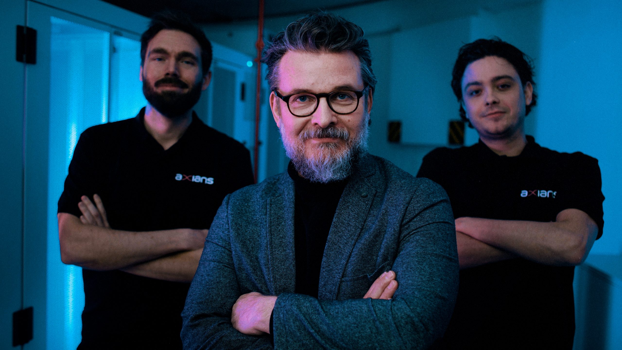 Axians sfeerbeeld, mannen poseren met armen over elkaar