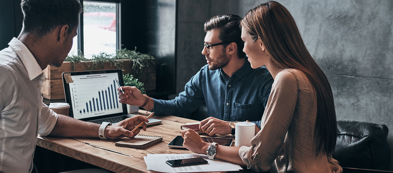 Drie collega's werken samen achter een laptop