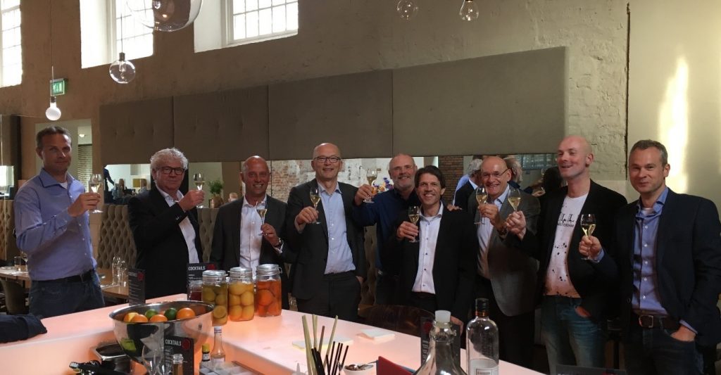 Een groep mensen proost op de overname van VCD door Axians