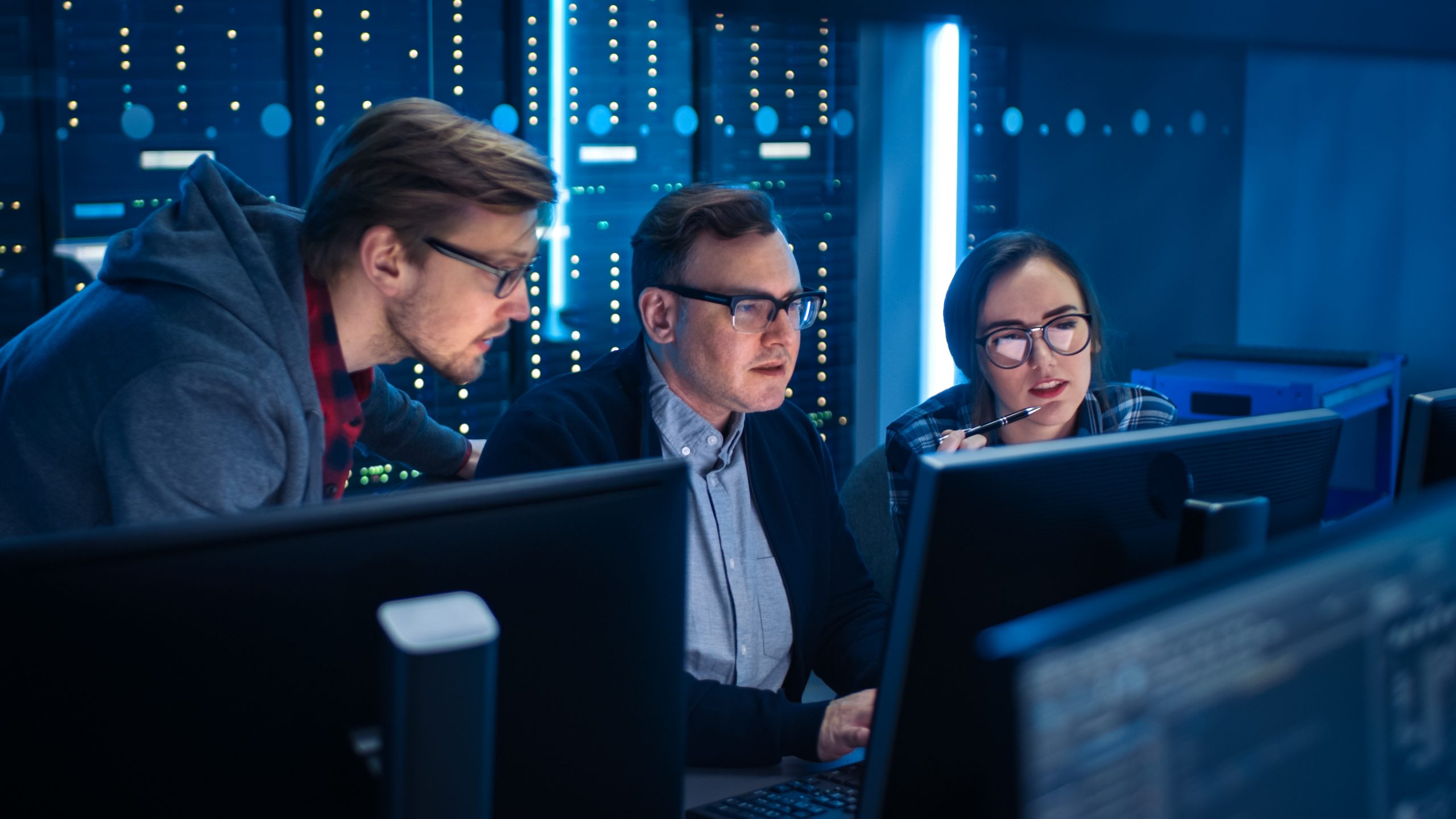Axians sfeerbeeld, mannen en vrouw werken achter computer