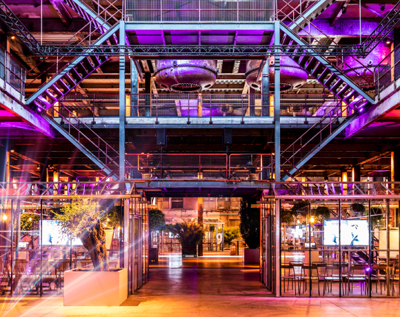 Foto van een van de zalen van de Sugar Factory, trappenhuis met metalen trappen, lichtstralen in de hoek