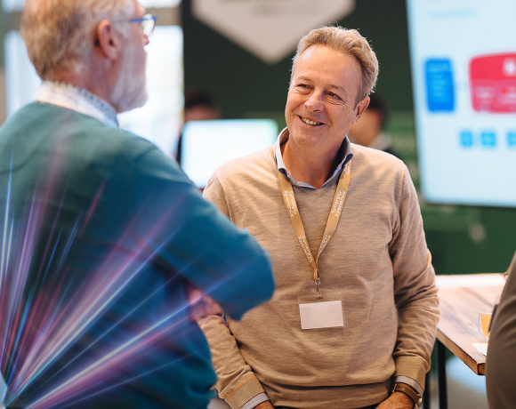 Foto van twee mannen in gesprek tijdens een werkevent