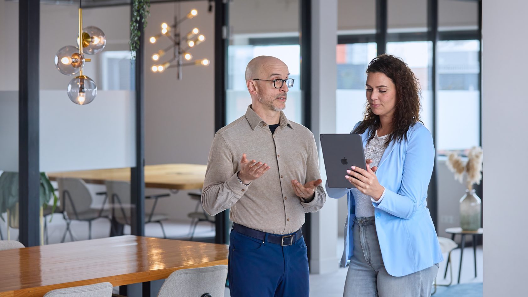 Synergy-experts overleggen achter een tablet over het optimaliseren van hun Exact Synergy-omgeving