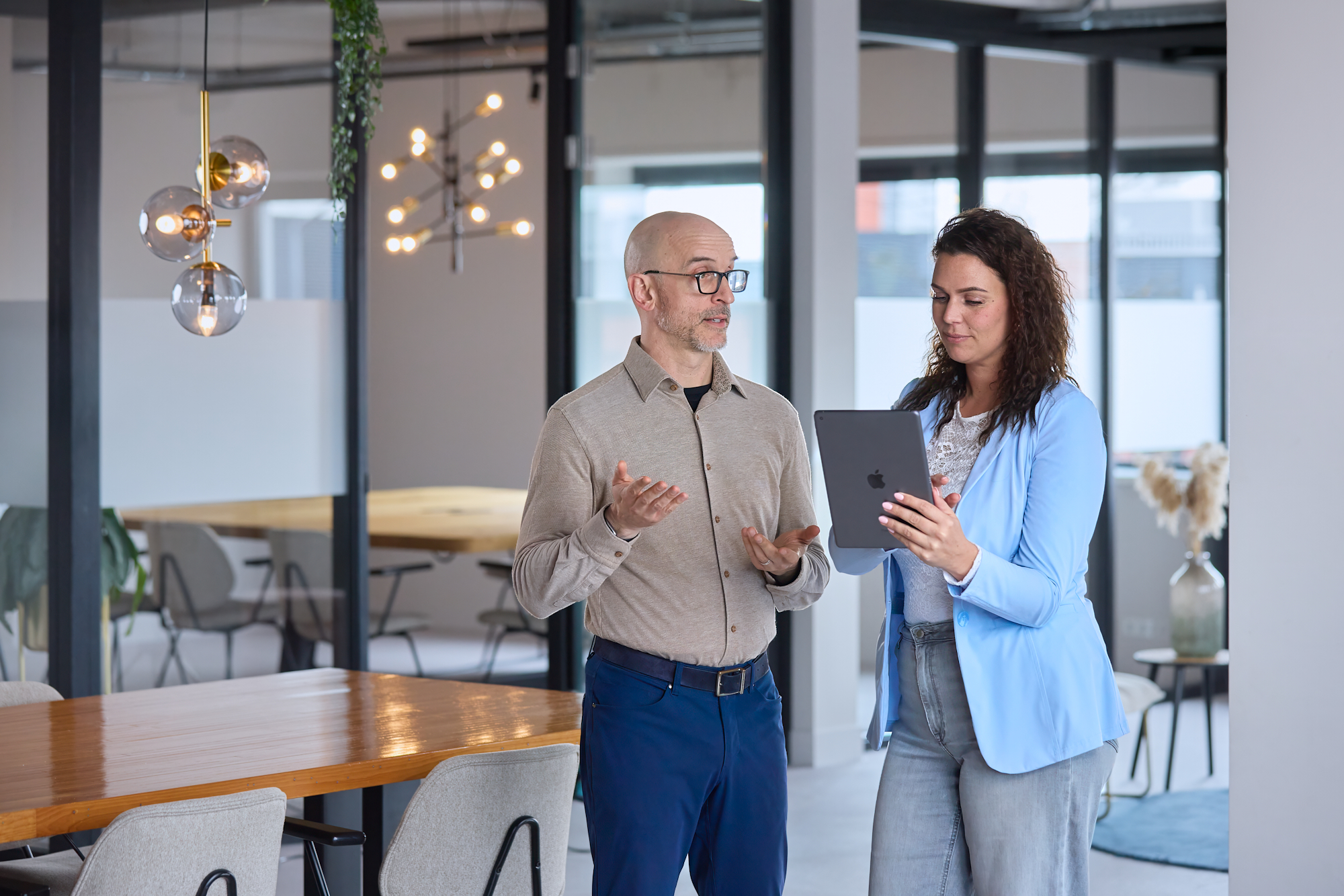 Synergy-experts overleggen achter een tablet over het optimaliseren van hun Exact Synergy-omgeving