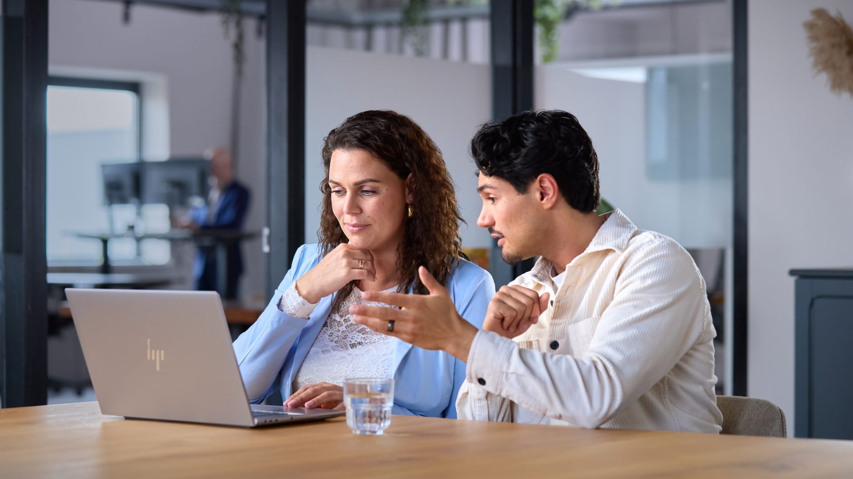 Synergy-experts overleggen over Exact Synergy achter een laptop