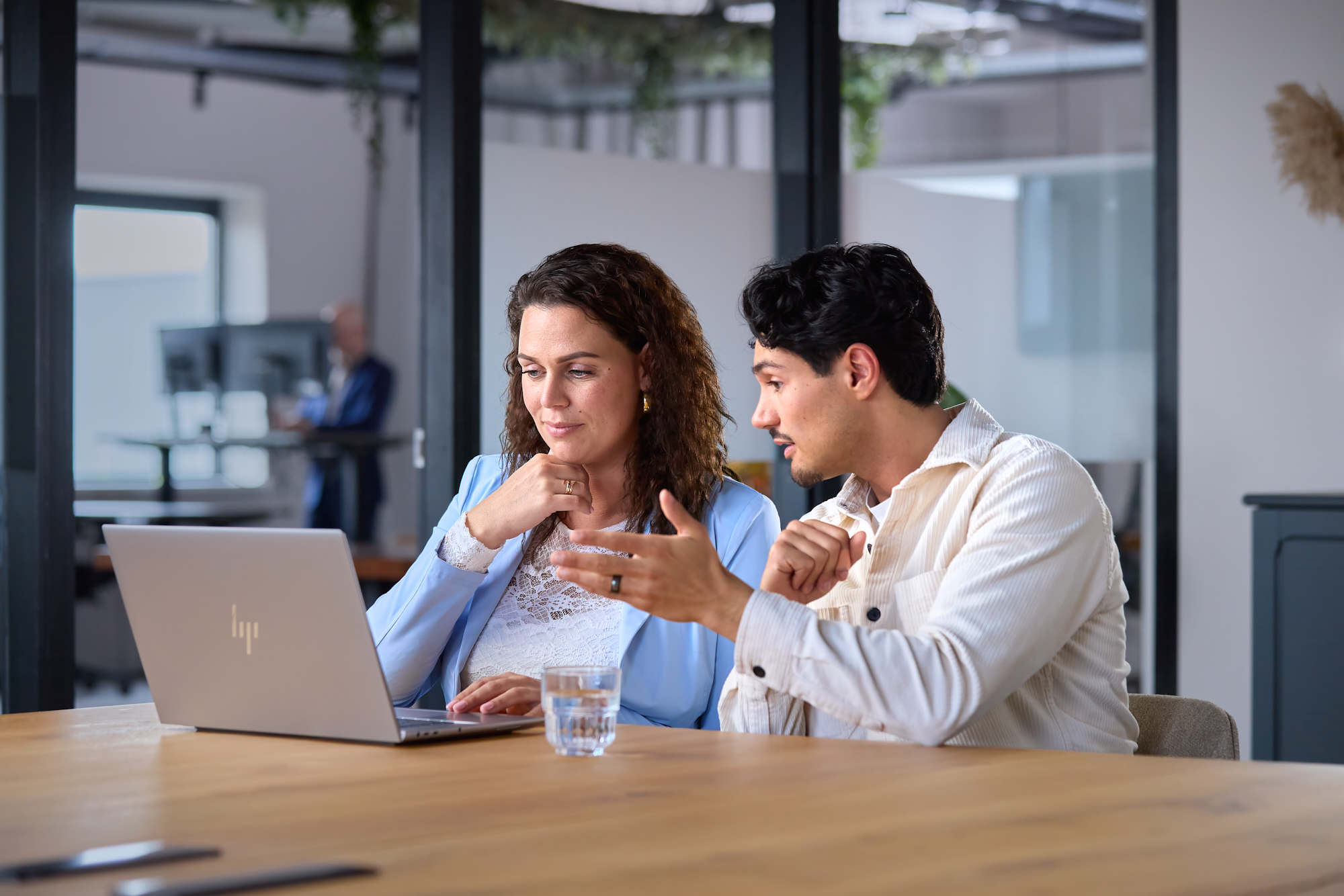 Synergy-experts overleggen over Exact Synergy achter een laptop